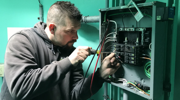 A Facilities staff member works on a piece of equipment