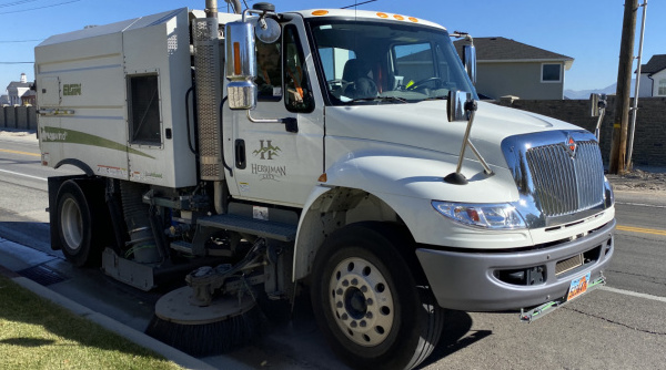 A Herriman City street sweeper truck cleans the roadside