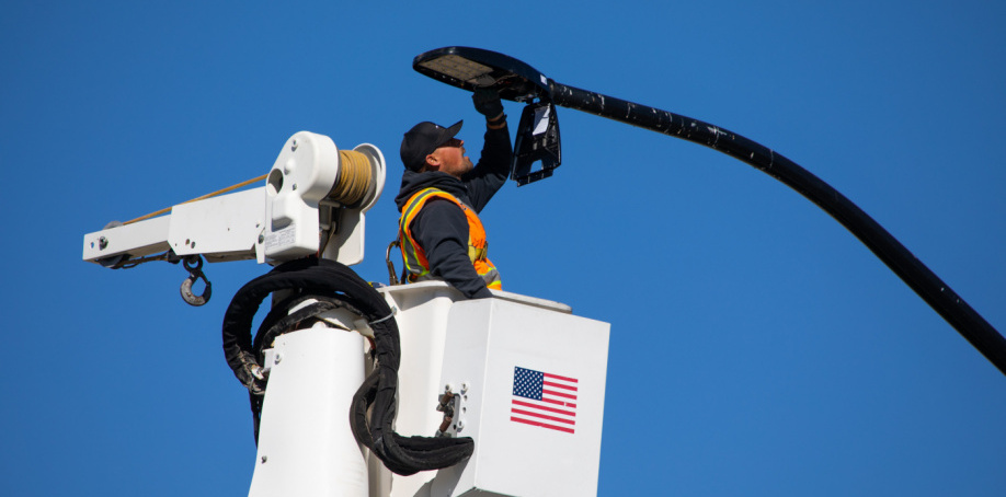 A Street Lights Department staff member in a bucket truck repairs a street light in Herriman